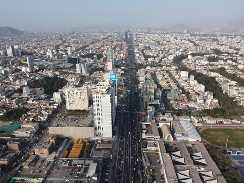 Aerial view of modern high-rise buildings, busy highways, and dense residential areas in San Isidro, Provincia de Lima, Peru.