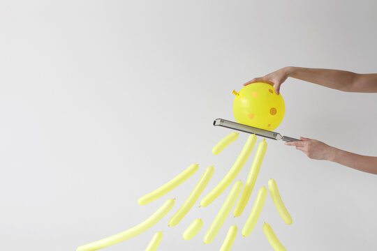 Close-up side view of a woman's hands grating a conceptual block of cheese using a cheese grater