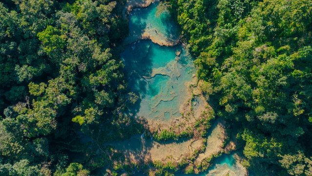 Aerial view of Semuc Champey with its turquoise limestone pools surrounded by lush tropical jungle and dense forest in San Agustin Lanquin, Alta Verapaz Department, Guatemala.