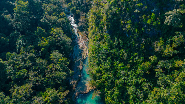 Aerial view of the turquoise pools of Semuc Champey surrounded by dense tropical rainforest and lush greenery in San Agustin Lanquin, Alta Verapaz, Guatemala.