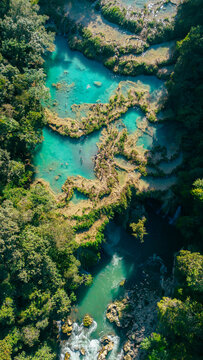 Aerial view of the turquoise limestone pools of Semuc Champey surrounded by lush tropical rainforest in San Agustin Lanquin, Alta Verapaz Department, Guatemala.