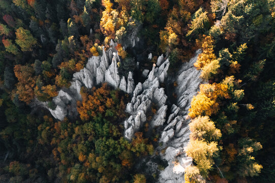 Aerial view of the Earth Pyramids of Auna di Sotto surrounded by vibrant autumn foliage in the forest of Unterinn, Trentino-Alto Adige, Italy.