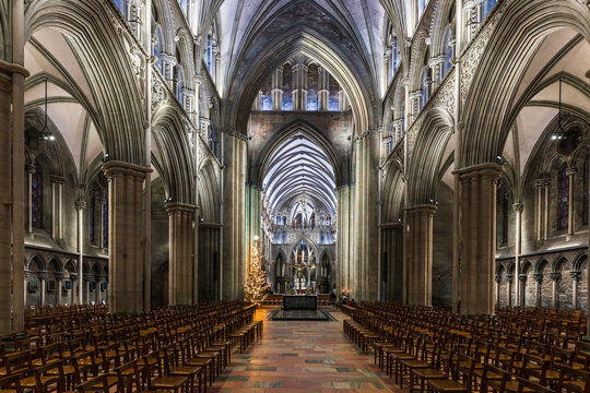 Trondheim, Norway - 30 December 2024: View of Nidaros Cathedral interior with its soaring gothic arches, stone columns, and rows of wooden chairs.