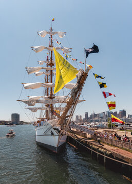 Boston, United States - 12 July 2026: View of the tall ship BAE Guayas of Ecuador docked in the harbor with colorful signal flags, white sails, and the Boston city skyline in the background.