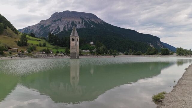 The bell tower of the church remains from the flooded village Graun - Curon in Val Venosta, South Tyrol, Italy