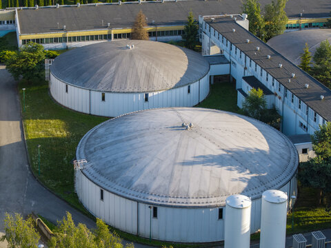 Aerial view of the water treatment facility with large circular tanks and industrial buildings situated in the green landscape of Dobczyce, Lesser Poland Voivode, Poland.