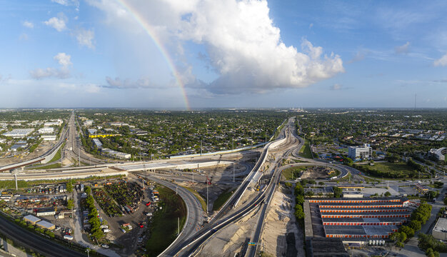 Aerial view of the Golden Glades Interchange under construction with a rainbow in the sky over the urban landscape of Miami, Florida, United States.