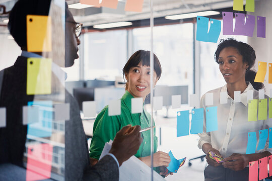 Colleagues brainstorm ideas on a glass wall in a London office
