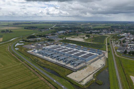 Aerial view of a large data center facility surrounded by green fields, industrial infrastructure, and rural landscape in Winschoten, Netherlands.