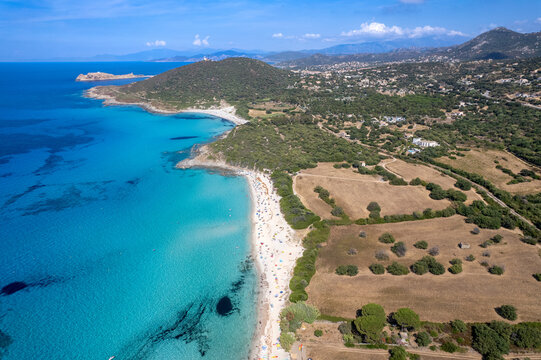 Aerial view of Plage de Ghjunchitu with turquoise waters, sandy beach, Mediterranean coastline, and lush green vegetation in Corbara, Corse, France.