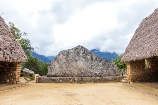 View of the Temple of the Condor at the historic Inca citadel of Machu Picchu with stone walls and thatched roofs in Cusco, Cusco, Peru.