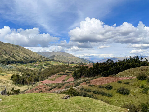 View of the rolling landscape and agricultural fields in the Andes mountains near Cusco, Cusco, Peru.