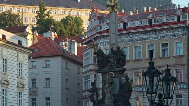 Holy Trinity Plague Column stands on Lesser Town Square in Prague. Majestic Prague Castle and Saint Vitus Cathedral rise in soft morning light. Ideal for European and Czech tourism concepts.