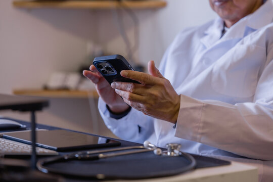 Doctor using smartphone for online communication, messaging and telemedicine in a modern clinic, representing digital healthcare, mobile technology, medical support and remote consultation.
