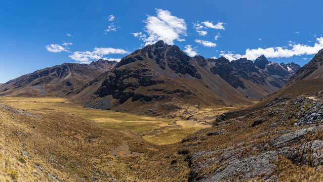 View of the rugged Andes mountains with dry grassy valleys and rocky slopes in Ancash, Peru.