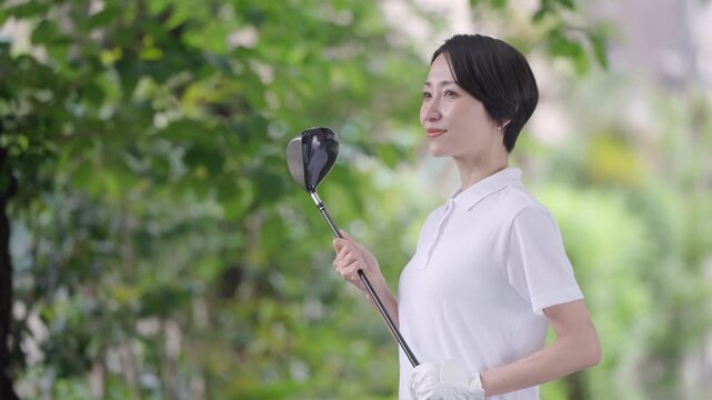 ゴルフをする笑顔の女性