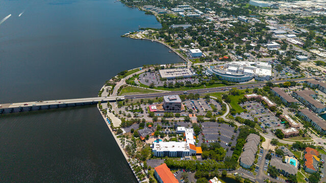 Aerial view of Downtown Bradenton featuring the Manatee River, the Green Bridge, urban buildings, parking lots, and surrounding greenery in Bradenton, Florida, United States.