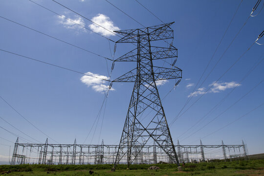 View of Kenya Power Suswa Substation with a large high-voltage transmission tower and electrical infrastructure set against a clear blue sky in Mirera, Nakuru County, Kenya.