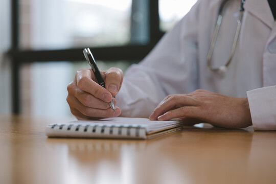 Doctor writing medical notes at a desk with stethoscope in clinic, representing healthcare documentation, patient records, diagnosis, prescription, medical consultation and professional care.