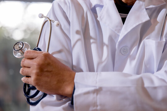 Doctor holding a stethoscope while standing in a modern clinic, representing professional healthcare, medical service, patient care, diagnosis, trust and clinical expertise in medicine.