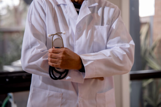 Doctor holding a stethoscope while standing in a modern clinic, representing professional healthcare, medical service, patient care, diagnosis, trust and clinical expertise in medicine.