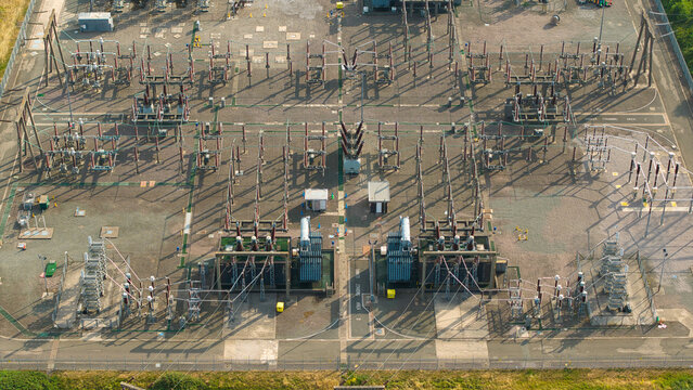 Aerial view of Berkswell Substation featuring complex electrical transformers, switchgear, and metal infrastructure on a gravel site in Coventry, England, United Kingdom.