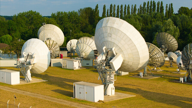 Aerial view of Satellite Mediaport Services Ltd. with large satellite dishes set in a grassy field surrounded by trees in Long Lawford, England, United Kingdom.