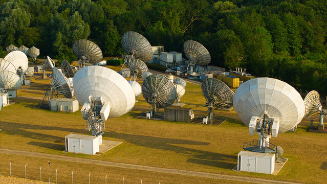 Aerial view of Satellite Mediaport Services Ltd. featuring large satellite dishes and communication antennas in a grassy field in Long Lawford, England, United Kingdom.