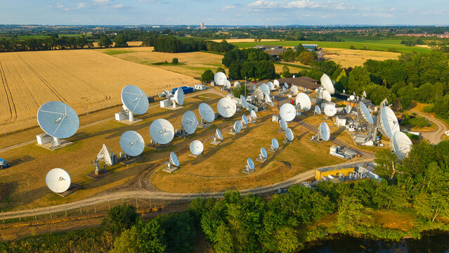 Aerial view of Satellite Mediaport Services Ltd. with numerous satellite dishes arranged in a field surrounded by agricultural land in Long Lawford, England, United Kingdom.