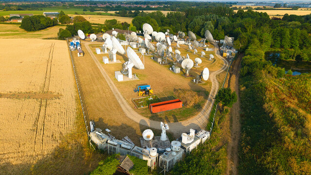 Aerial view of Satellite Mediaport Services Ltd. featuring numerous satellite dishes and telecommunications equipment in a rural landscape in Long Lawford, England, United Kingdom.