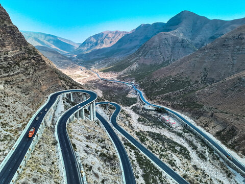 Aerial view of Steel Bridge Fort Munro with its winding road through the rugged mountain landscape under a clear blue sky in Dera Ghazi Khan, Punjab, Pakistan.