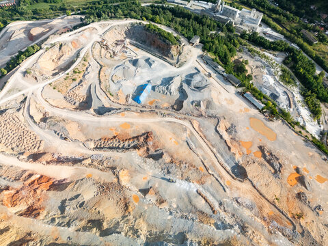 Aerial view of the stone quarry and gravel pit with industrial equipment and excavated terrain in Tisovec, Banska Bystrica Regio, Slovakia.