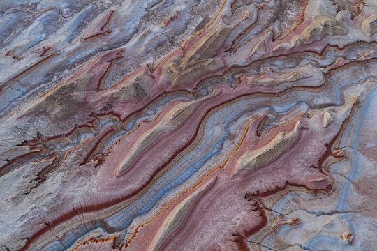 Aerial view of the colorful, layered sedimentary rock formations of the Aktau Mountains in Altyn-Emel National Park, Kazakhstan.