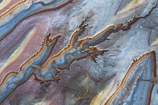 Aerial view of colorful geological strata and erosion patterns in the desert landscape of Kazakhstan.