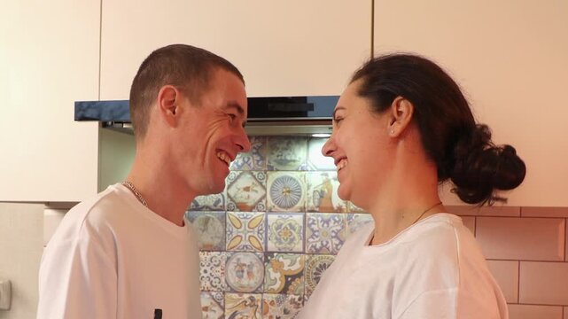 Portrait of happy couple standing together in a cozy kitchen while enjoying quality time. Their affectionate interaction demonstrates emotional intimacy, partnership, and everyday romance.