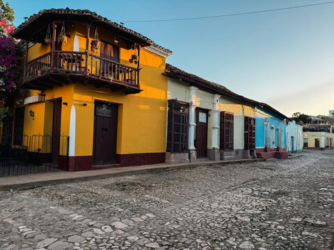 Cuba - 20 December 2024: View of colorful colonial-style buildings with a yellow facade, a wooden balcony, and cobblestone streets in Cuba.