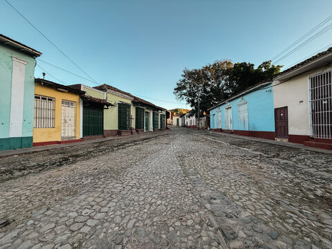 Cuba - 20 December 2024: View of a historic cobblestone street lined with colorful colonial houses under a clear blue sky.