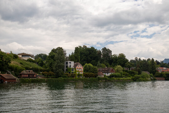 View of houses nestled among lush trees along the shore of Lake Lucerne, Lucerne, Lucerne, Switzerland.