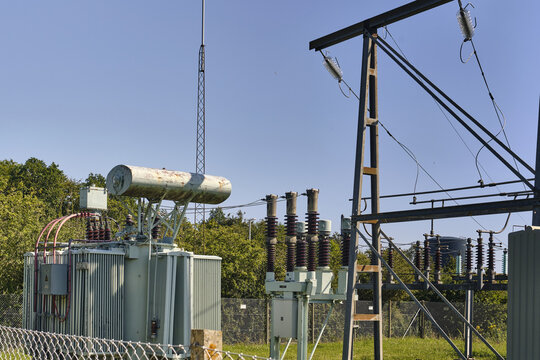 Nordborg, Denmark - 12 July 2026: View of the high voltage transformer station at the Danfoss factory with electrical equipment, metal structures, and green trees under a clear blue sky.