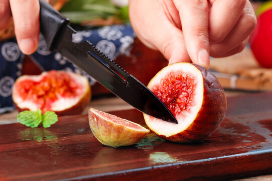 Fresh Figs Being Sliced with Mandoline Slicer Showing Red Flesh and Seeds on Wooden Cutting Board