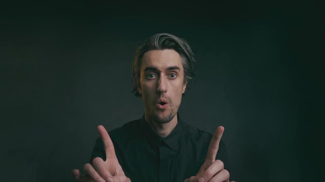 that's how it is Middle-aged man with gray wavy hair making expressive hand gestures and facial expressions in a dark studio setting with soft dramatic lighting, ideal for communication themes