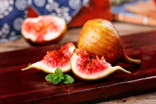 Fresh Red Flesh Figs on Wooden Board - Ripe Sweet Fruit with Mint Garnish