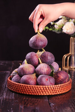 Fresh Purple Figs in Wicker Basket - Hand Picking Ripe Fruit on Dark Wood Table