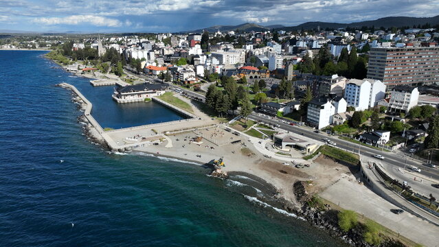Aerial view of the waterfront of Bariloche, featuring the shoreline of Nahuel Huapi Lake, urban buildings, and roads in Bariloche, Rio Negro, Argentina.