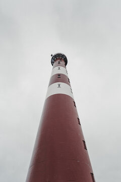 Gamvik, Finnmark, Norway - 26 August 2025: View of Slettnes Lighthouse rising against a cloudy sky with its iconic red and white stripes.