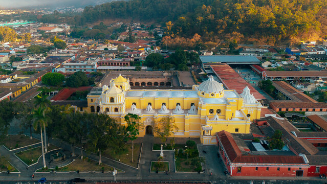 Aerial view of the historic La Merced Church with its yellow facade and white domes, surrounded by colonial architecture and trees in Antigua Guatemala, Sacatepequez Department, Guatemala.
