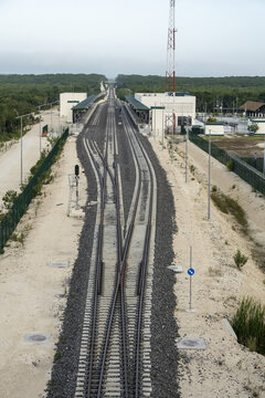 View of the Tren Maya railway station with tracks, gravel ballast, and a communication tower surrounded by forest in Calakmul, Campeche, Mexico.