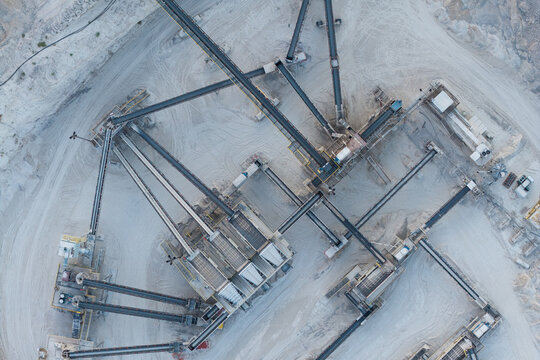 Aerial view of an industrial mining facility featuring complex conveyor belt systems and processing equipment set against a dusty, excavated landscape in Las Vegas, Nevada, United States.