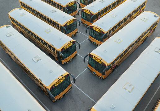 Aerial view of a fleet of yellow school buses parked in neat rows within a paved lot in Las Vegas, Nevada, United States.