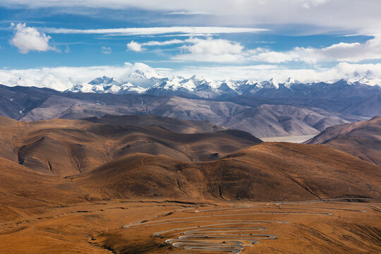 View of Mount Everest View Point with snow-capped peaks, winding road, and arid landscape in Tibet, China.